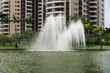 Park with buildings and a large green area in the midst of nature and the dance of water in the fountain of the lake