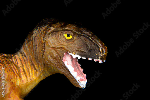 Close up of toy dinosaur isolated on black background, mouth open, T-rex, Tyrannosaurus