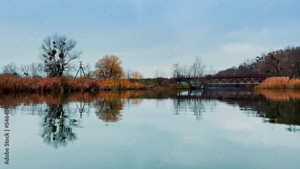 Looking at the dry waterfront from the river. Metal bridge connecting the banks and beautiful modern house near the water. Autumn nature out of big city. Looking at the dry waterfront from the river. Metal bridge connecting the banks and beautiful modern house near the water. Autumn nature out of big city.