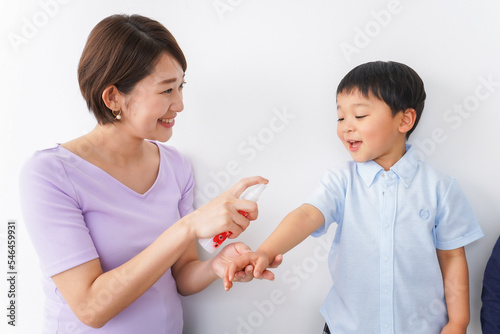 子どもにスプレーをするお母さん