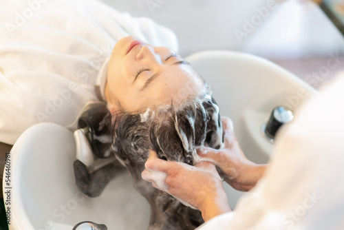 Leinwand Poster シャンプー台でシャンプーをする美容師