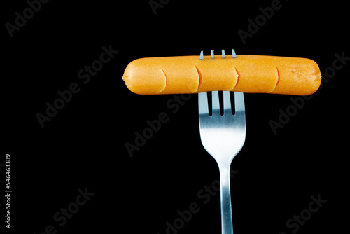 sausage on a fork and isolate black background