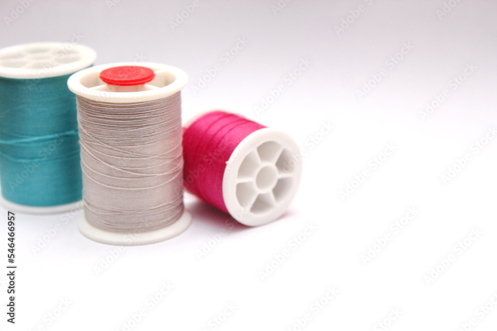 Green, red, colored thread spools placed on a white background. Green, red, colored thread spools placed on a white background.
