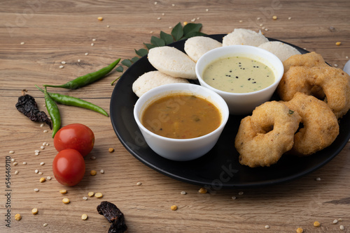 South Indian breakfast-Idli, sambar, wada, coconut chutney. Served in plate wooden background photo