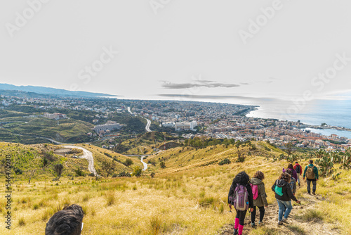 Panorama di Reggio Calabria vista dalla collina di Pentimele con escursionisti che scendono il sentiero