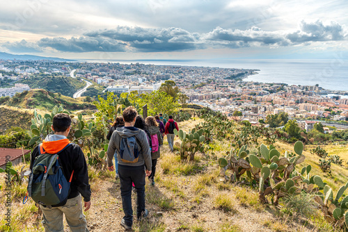 Panorama su Reggio Calabria dalla collina di Pentimente con gruppo di escursionisti sul sentiero di spalle photo