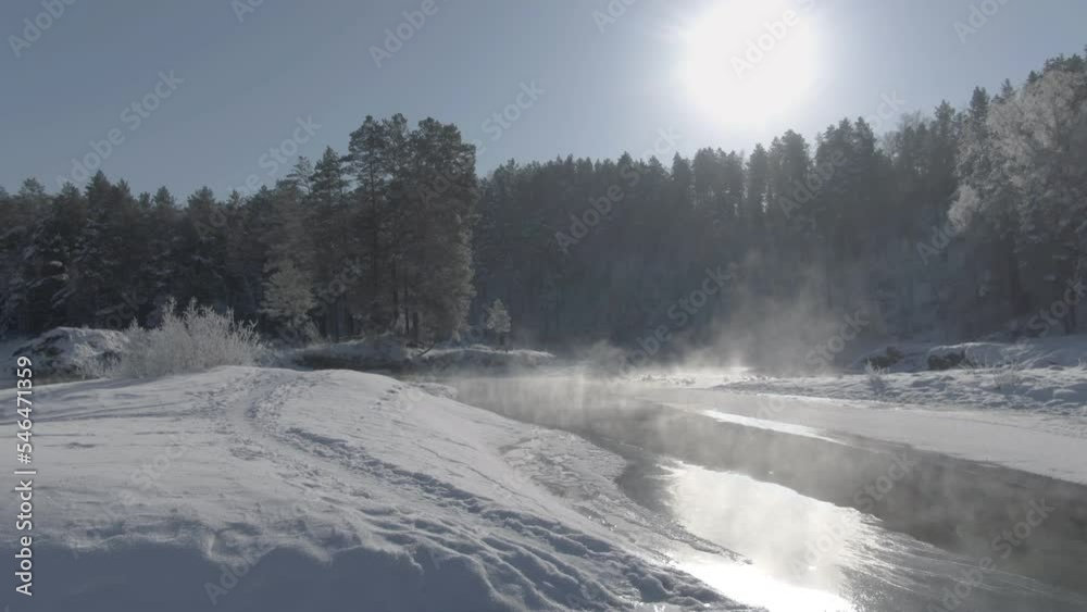 Low drone shot over a hot mountain lake surrounded by pine forest in winter Low drone shot over a hot mountain lake surrounded by pine forest in winter