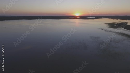 Boats on Calm Lake at Sunset. Aerial Flying Backwards Lift-Up POI photo