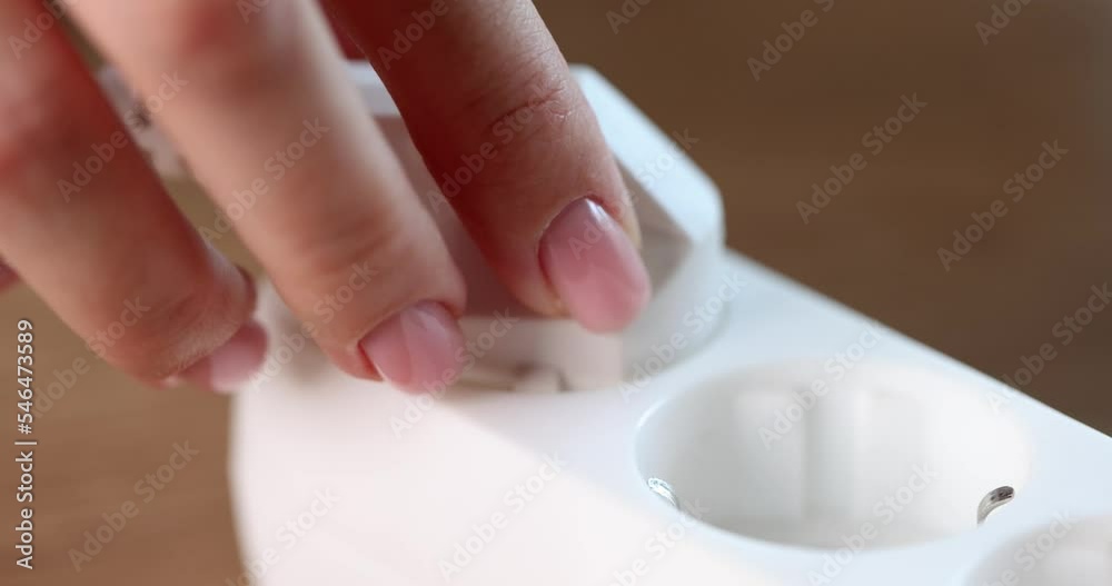 Closeup of hand inserting electric plug to save energy