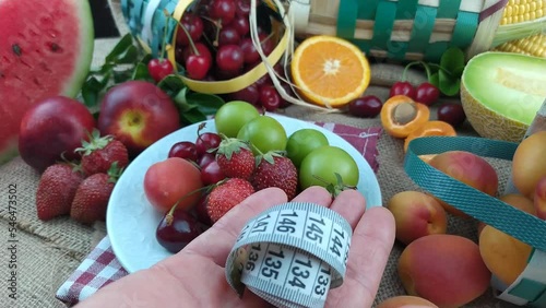 There is meter in hand opened on fruit background