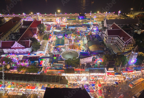 Aerial top view of amusement park in night temple fair, and night local markets. People walking street, Colorful tents in Bangkok city, Thailand. Retail shops