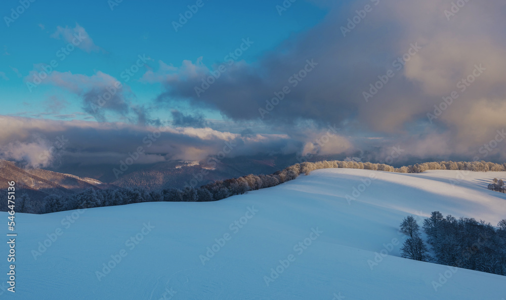 Mountain plateau covered with snow under a cloudy sky. Winter mountain landscape.
