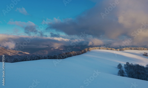 Mountain plateau covered with snow under a cloudy sky. Winter mountain landscape.