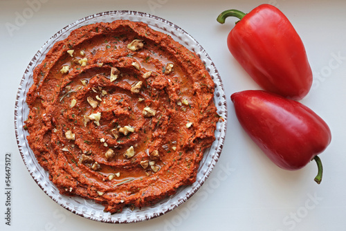 Muhammara, sauce of wholesome walnuts and roasted red bell peppers on a ceramic white plate