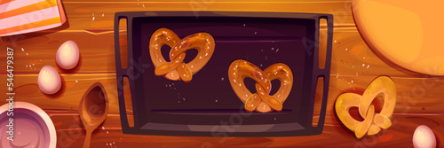 Top view kitchen table with pretzels on baking sheet. Vector cartoon illustration of dough, fresh cookies, eggs, wooden spoon. Process of cooking biscuits. Traditional family recipe of holiday dessert
