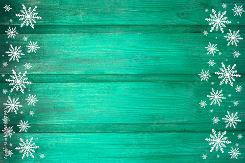 Winter wooden green mint turquoise nature background with snowflakes two sides. Texture of painted wood horizontal boards. Christmas, New Year card with copy space.
