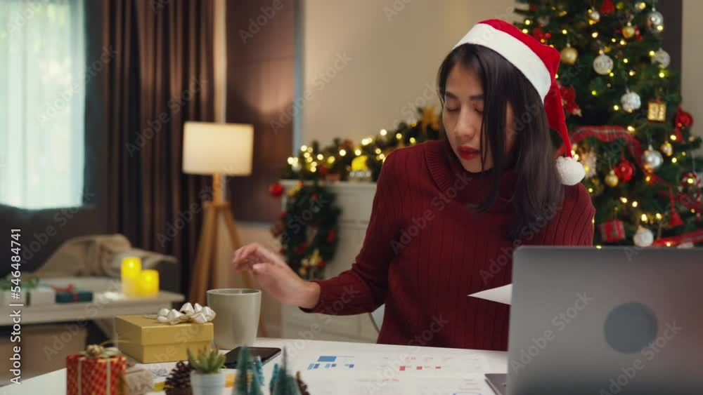 Attractive Asia female business owner wear sweaters sit on table new normal focus online work from house on computer laptop on christmas day relax with drink hot chocolate in mug stay at home working. Attractive Asia female business owner wear sweaters sit on table new normal focus online work from house on computer laptop on christmas day relax with drink hot chocolate in mug stay at home working.