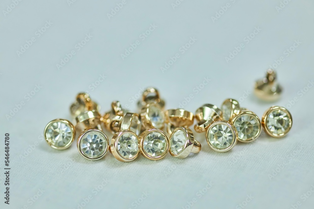 A set of gold-colored buttons with crystals. The concept of hobbies and crafts. A set of gold-colored buttons with crystals. The concept of hobbies and crafts.