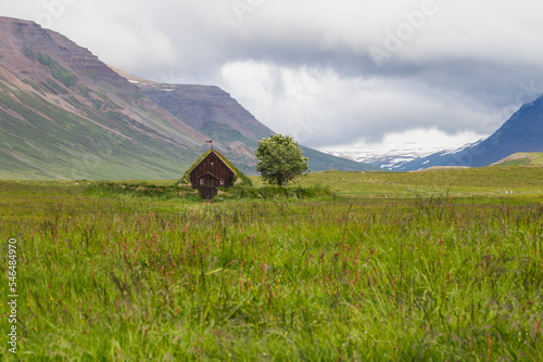 look through a valley with the oldest church of iceland. the Grafarkirkja church