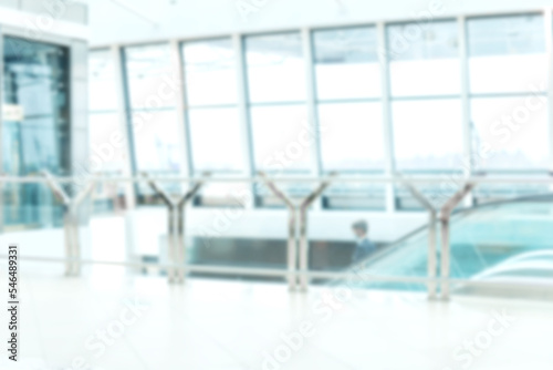 blurry image escalator in a spacious building of a modern airport .