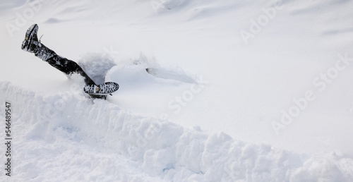 Man is falls headfirst into deep snow. Concept of winterly slippery conditions.