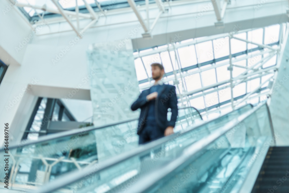 blurry image. passenger with luggage going up the escalator at the airport . blurry image. passenger with luggage going up the escalator at the airport .