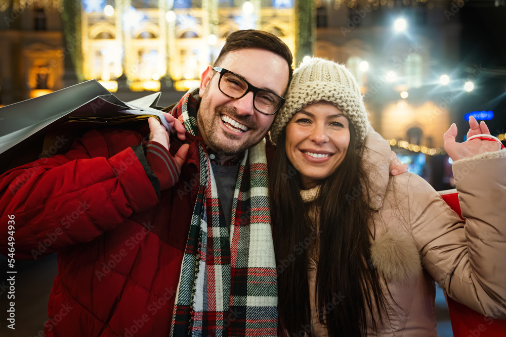 Φωτογραφία Portrait of happy smiling couple with Christmas presents in the city