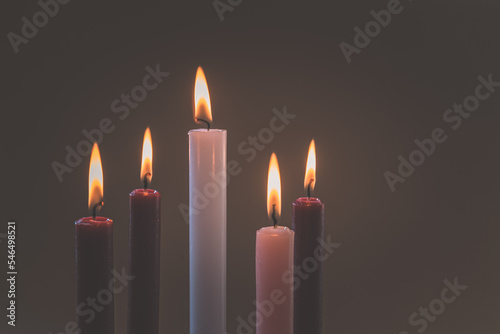5 candles burning on tradition christian advent wreath, black background