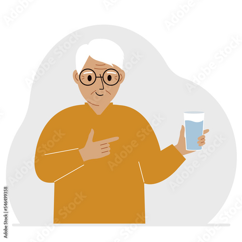 A old man holds a glass of water in his hand. The concept of water balance and health.