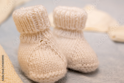 Knitted children's shoes for a boy on a light background, close-up, children's shoes. Postcard.