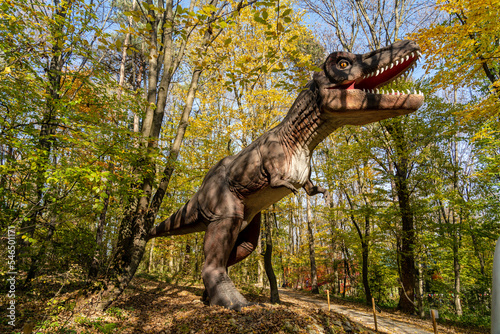 A huge dinosaur model in the forest. Dinosaur in the jungle