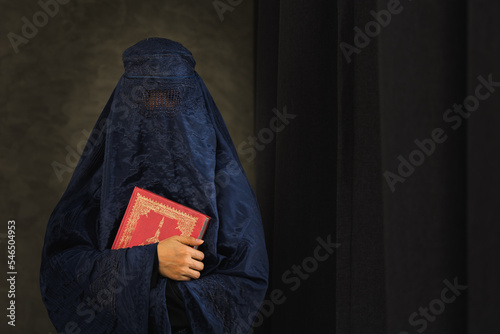 Asian women with burka reading the Islamic Quran photo