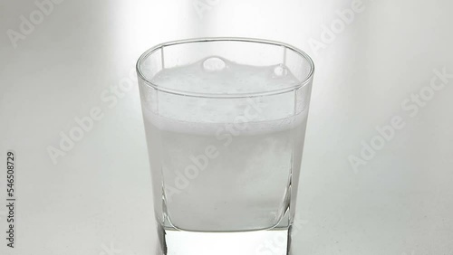 Mixing antacid in a glass of water photo
