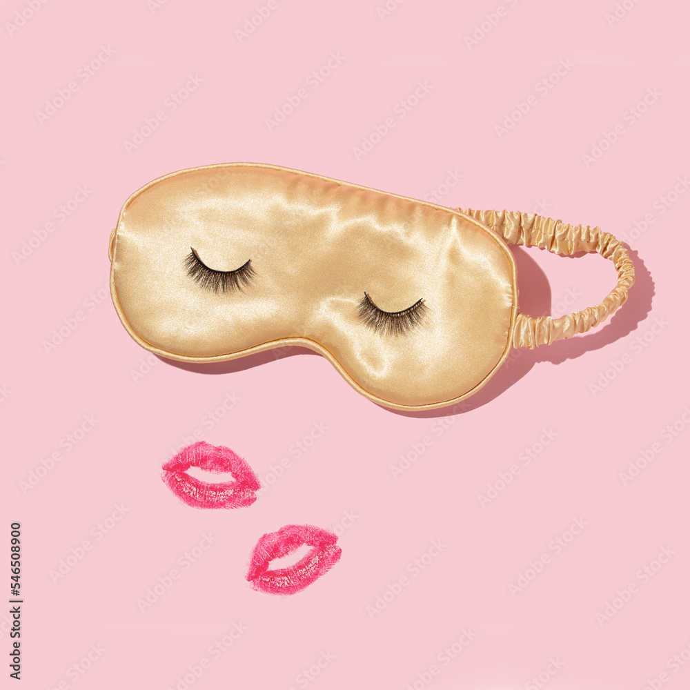 Creative layout with yellow sleep mask with false eyelashes and kiss