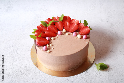 Delicious beautiful cake in chocolate glaze with strawberries and mint	
