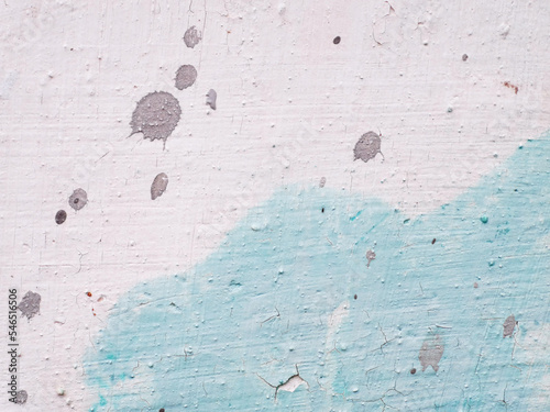 Dirty vintage two colored whyte blue stucco wall with grey cement stains. Stained cracked paint with grains photo