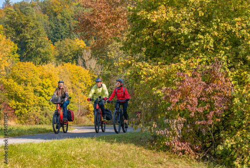 three happy senior adults, riding their mountain bikes in the autumnal atmosphere of the fall forests around city of Stuttgart, Baden Wuerttemberg, Germany 