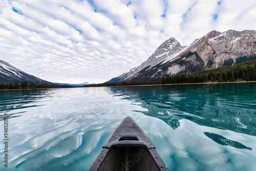 Canoeing on Maligne Lake with Rocky Mountains and cloudy sky in Jasper national park