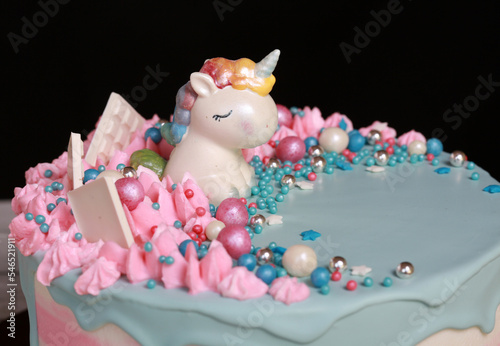 Close-up of a sweet fairy unicorn on a cake for children in pink and blue cream glaze