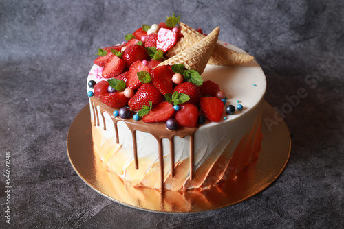 appetizing cake with strawberries, mint leaves and waffle cones