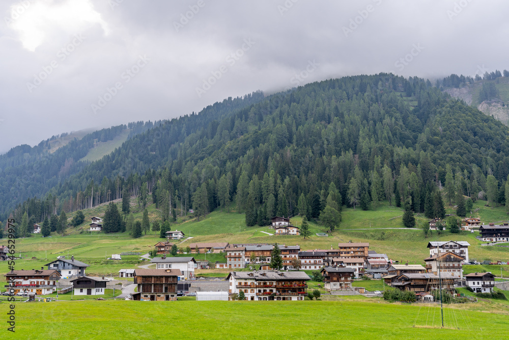 Obraz premium A small village next to a forest hill in alps, Sauris, Italy