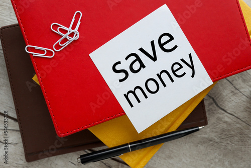 SAVE MONEY text on paper on a red notepad. working table
