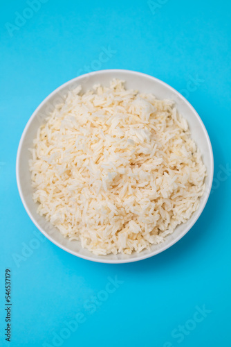 Boiled rice in a bowl on blue paper