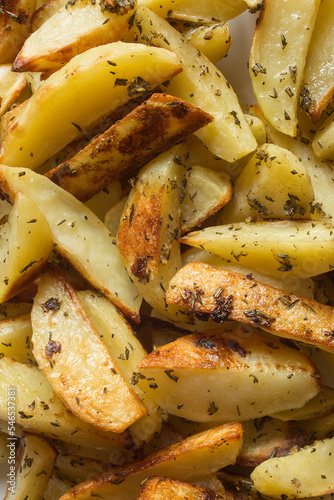 Close-up detail of a pile of freshly baked rosemary potatoes. Potatoes and food.