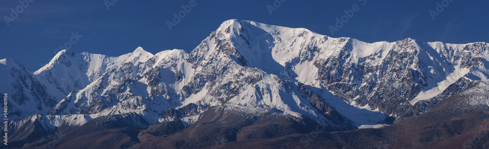 Obraz premium Snow-capped mountain peaks, contrasting morning light, large panorama