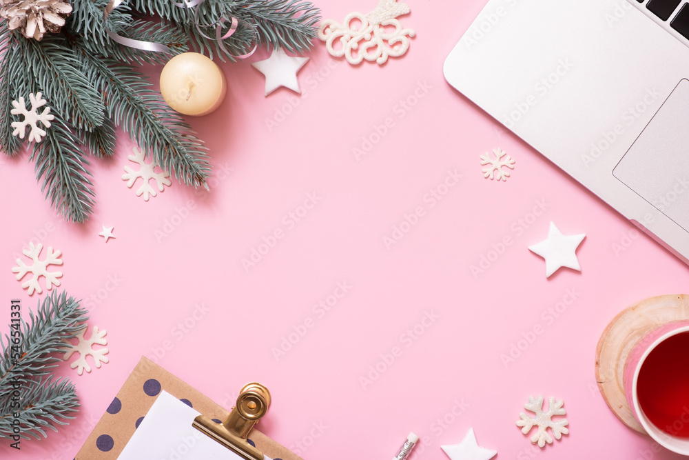 Office work table with Christmas and New Year decoration top view, flat lay on pink background. Copy space for text during winter holidays