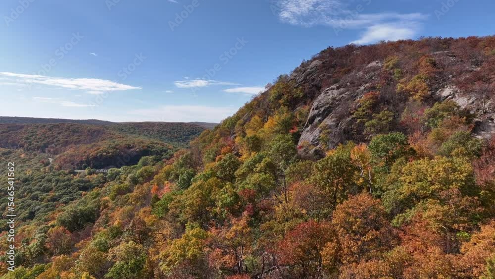 An aerial view just above the mountains in upstate NY in the fall. Taken on a beautiful day with white clouds. The camera dolly in next to the mountain side. An aerial view just above the mountains in upstate NY in the fall. Taken on a beautiful day with white clouds. The camera dolly in next to the mountain side.