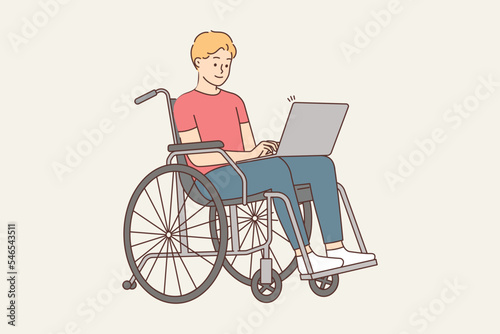 Smiling man in wheelchair work on computer 