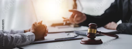 Obraz concept of justice and law A male judge in the courtroom on a wooden table and a male counselor or lawyer working in the office. Law, advice and justice concepts.