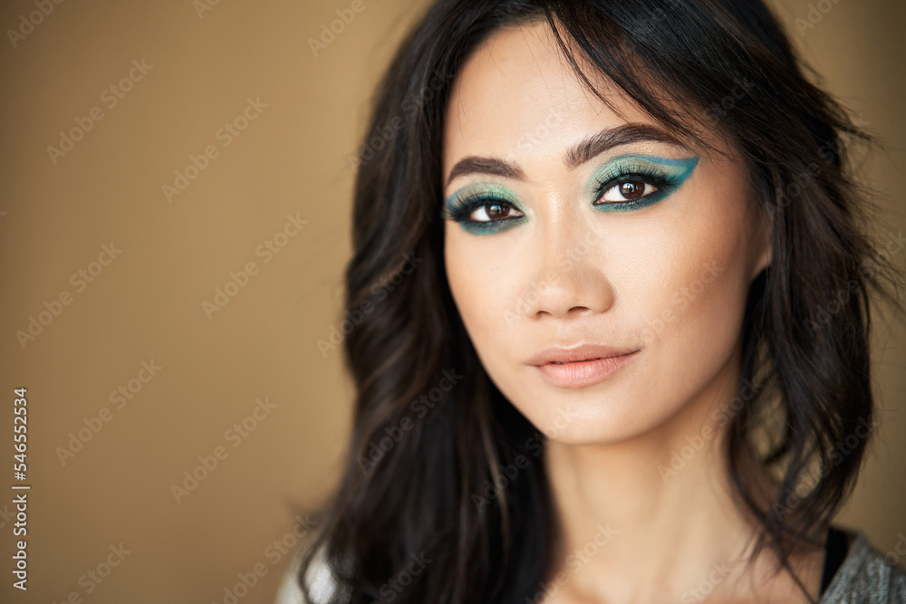 Portrait of beautiful asian girl model with long hair and bright makeup on beige background Portrait of beautiful asian girl model with long hair and bright makeup on beige background